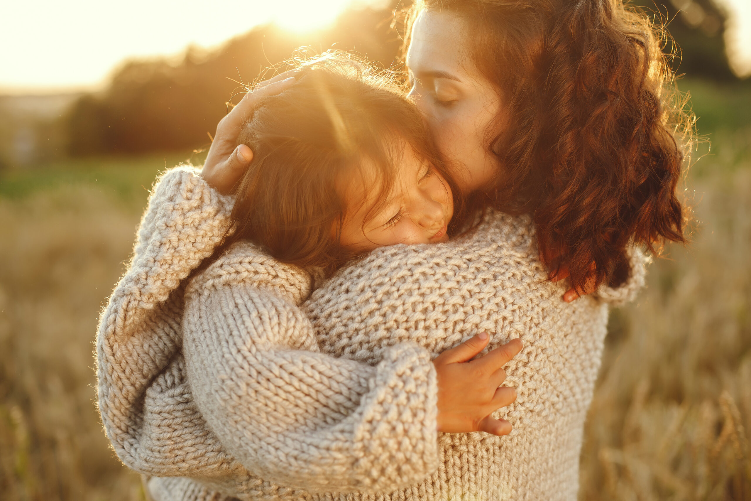 mother with daughter playing in a summer field